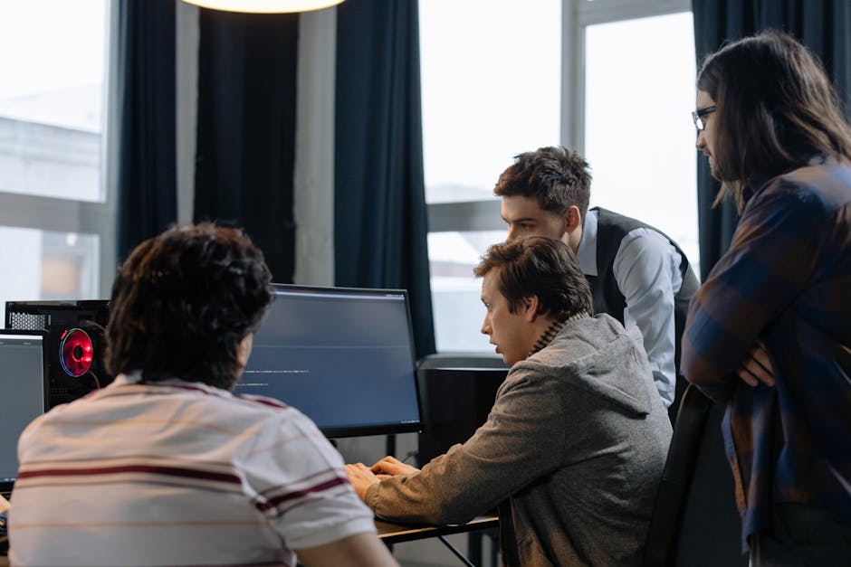 Group of developers working together on a computer programming project indoors